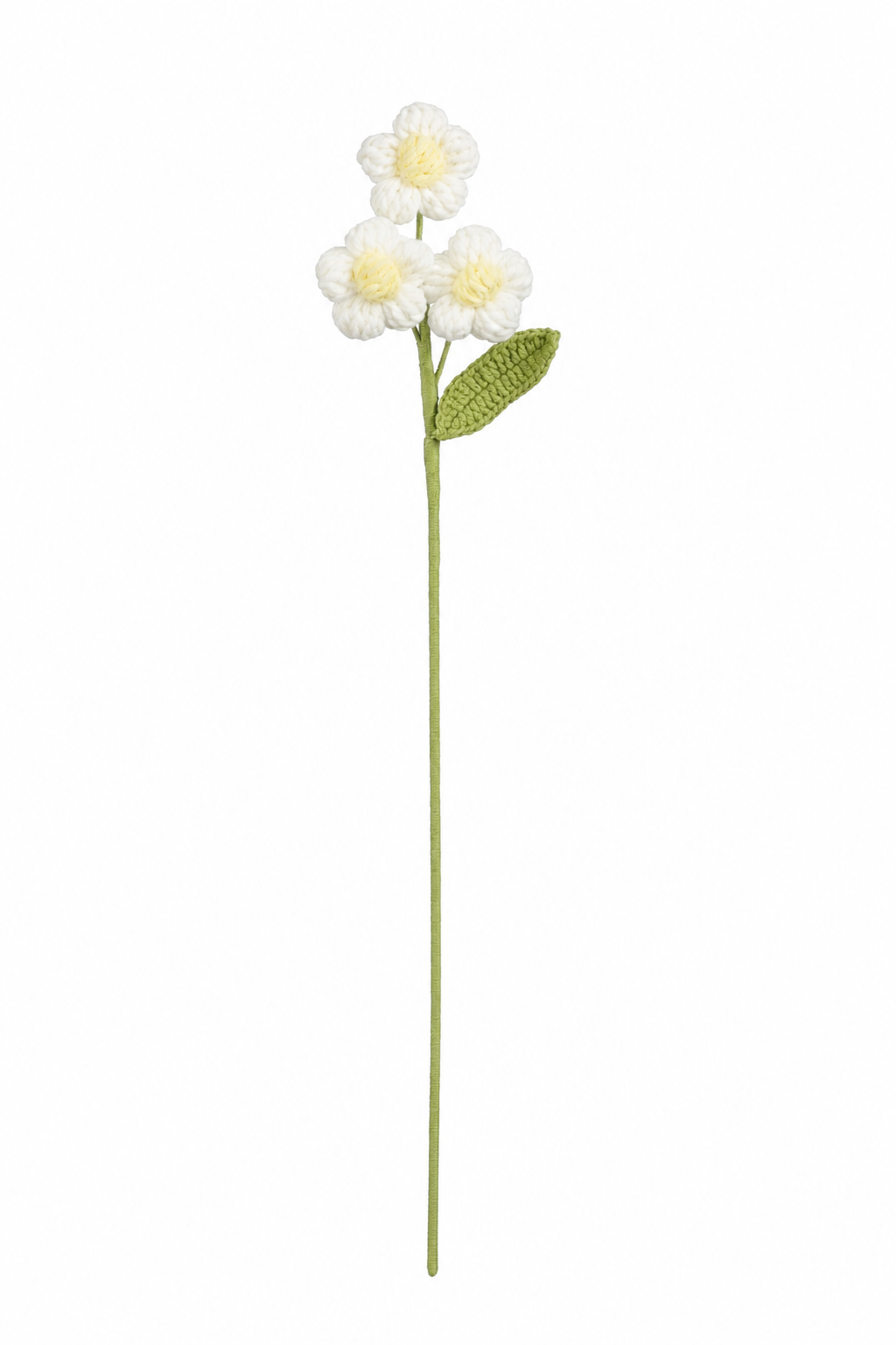 Hvid hæklet blomsterstilk med tre små blomster med gul midte og grønt blad