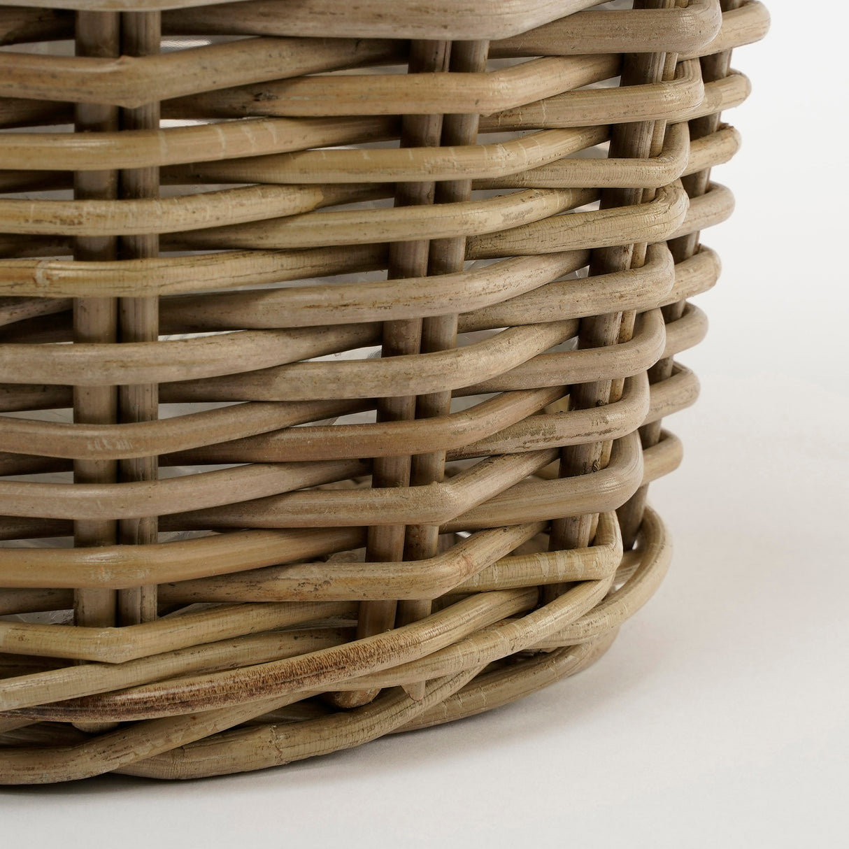 Bunden på Marcia rund kurv med hanke og plastinderside i grå rattan