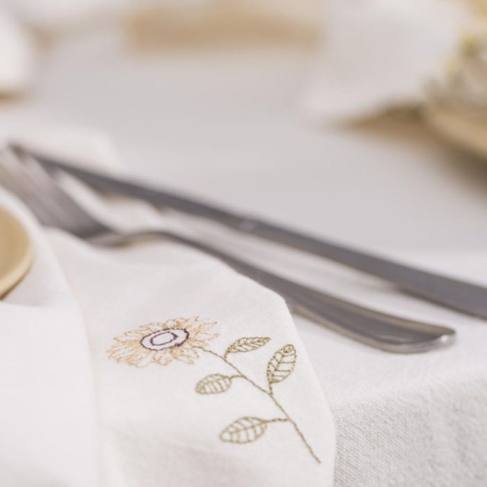 Ib Laursen Flora stofserviet butter cream med solsikke ved siden af bestik