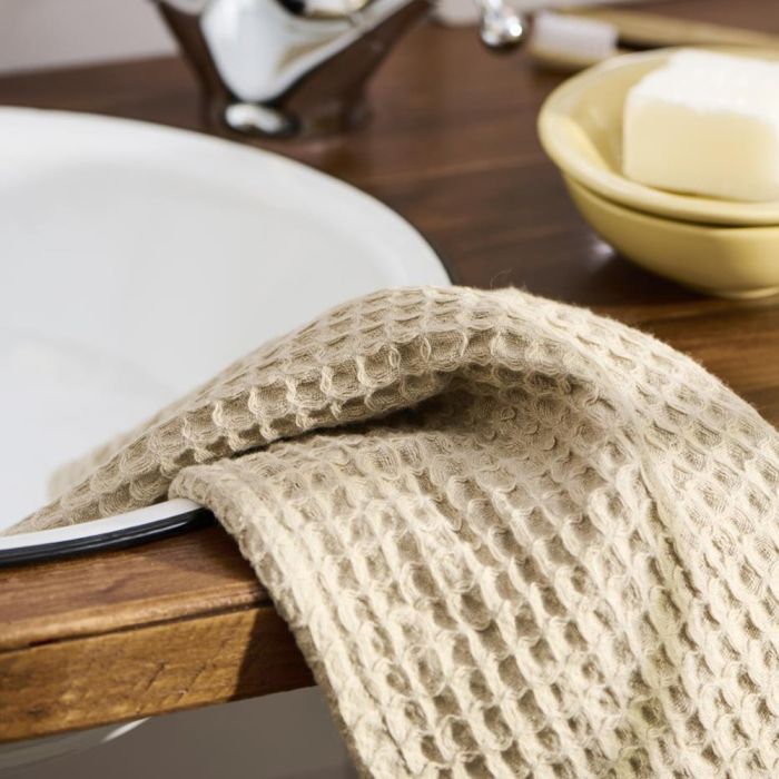 Ib Laursen Liseleje vaskeklud i beige ligger på kanten af en håndvask