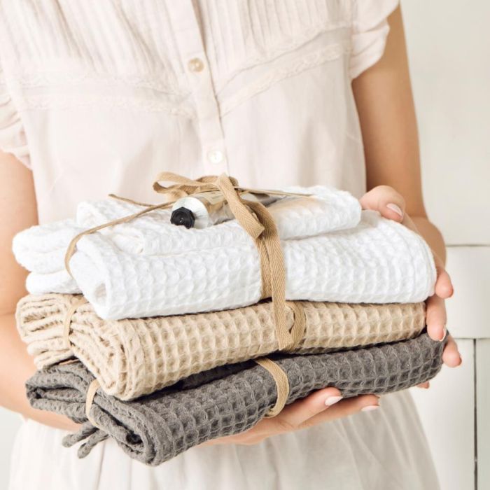 En person holder en stak Ib Laursen Liseleje vaskeklud i beige