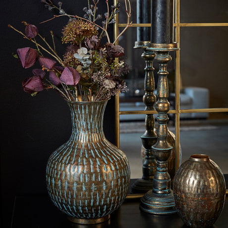 Metalvase med hamret struktur fra Speedtsberg  med blomsterbuket og lysestager