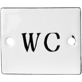 Hvidt emaljeskilt med teksten WC med sort typografi skrevet på