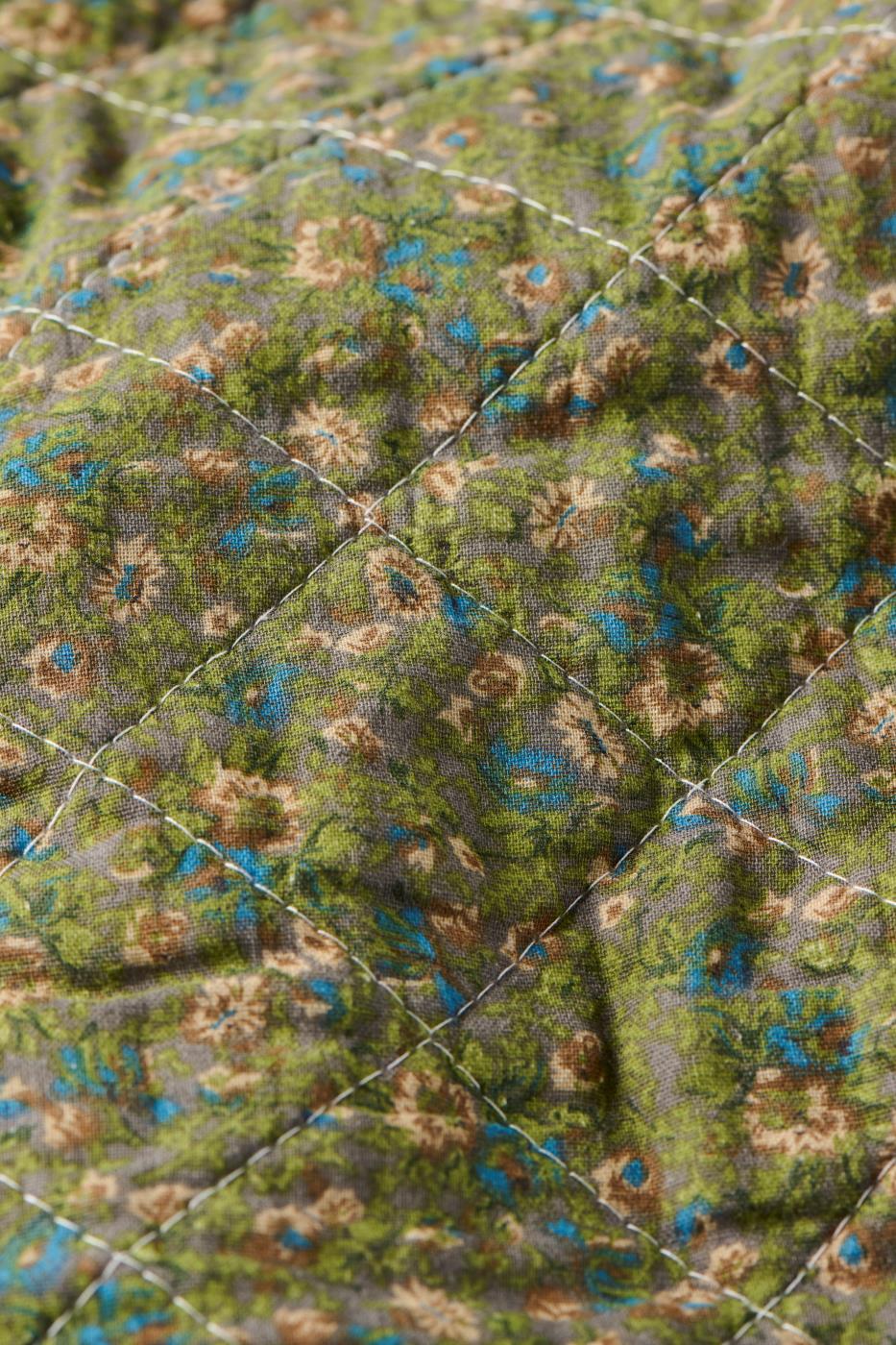 Nærbillede af småblomstret mønster på quilt fra Ib Laursen i dæmpede farver