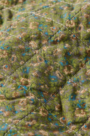 Nærbillede af småblomstret mønster på quilt fra Ib Laursen i dæmpede farver