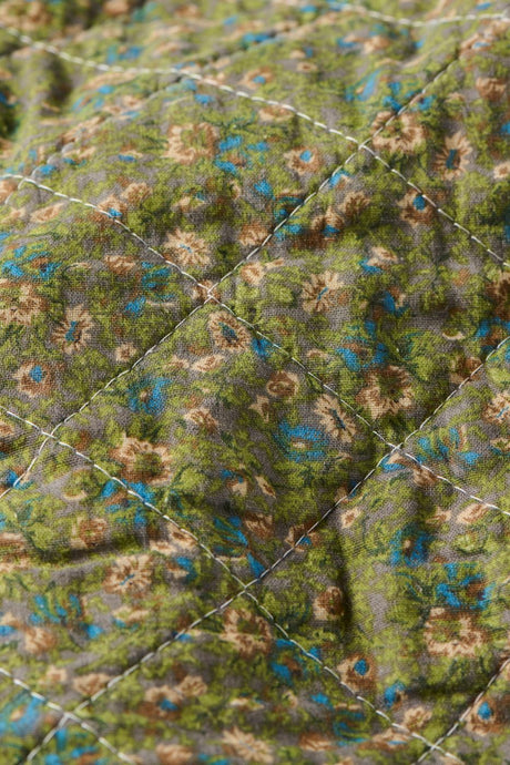 Nærbillede af småblomstret mønster på quilt fra Ib Laursen i dæmpede farver