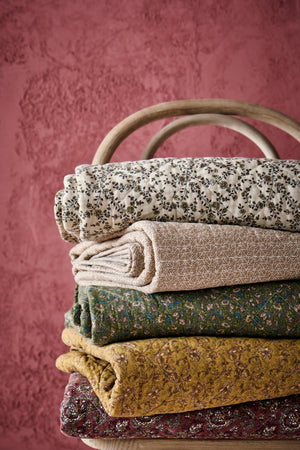 Stak af blomstrede og mønstrede quilts fra Ib Laursen i varme og afdæmpede farver