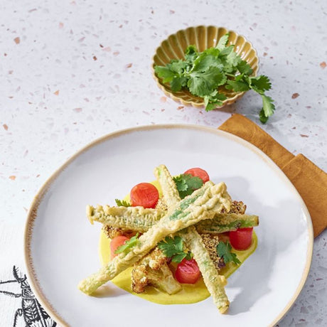 Pesca skål lille i okkerfarvet keramik med krydderurter ved siden af middagstallerken