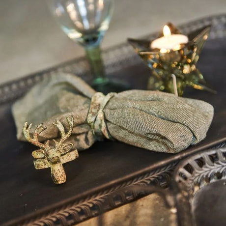 Servietring med hjort – antik grøn Speedtsberg foran stofdækkeserviet