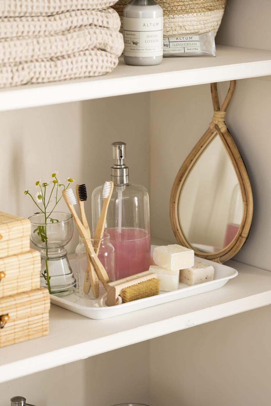 ALTUM neglebørste og sæber arrangeret på en bakke sammen med badeværelsestilbehør i naturmaterialer.