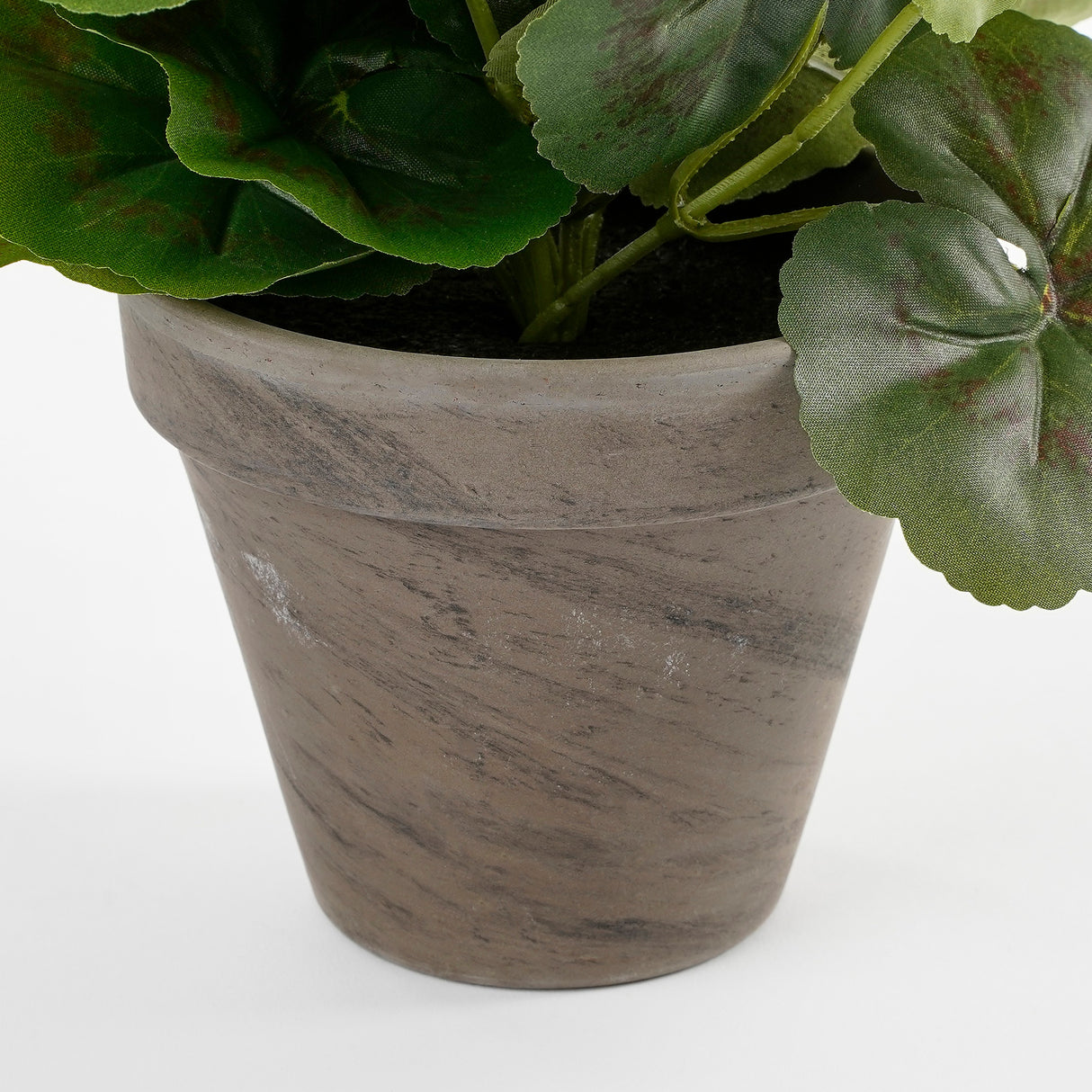 Grå lerpotte med struktur og kunstig pelargonie i