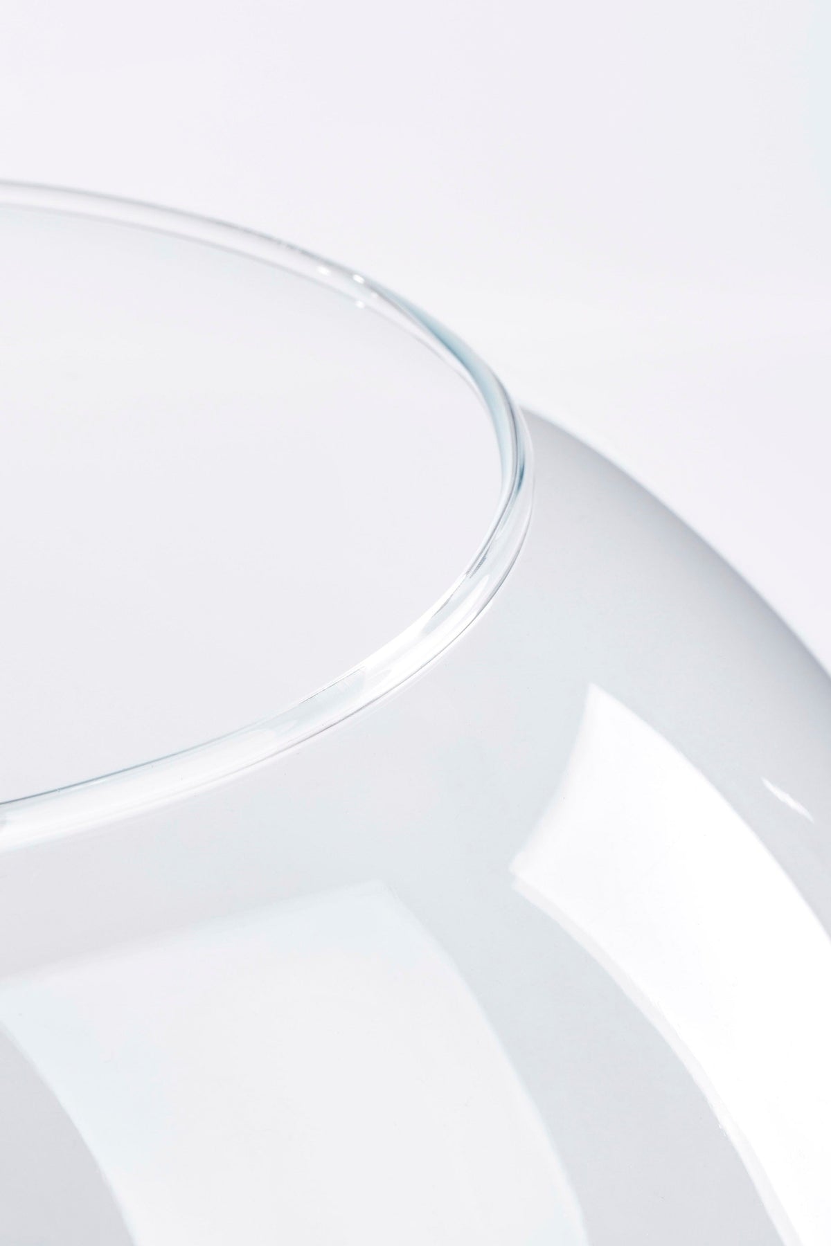 Detaljebillede af glasbowlens åbne kant og klare glas med afrundet form