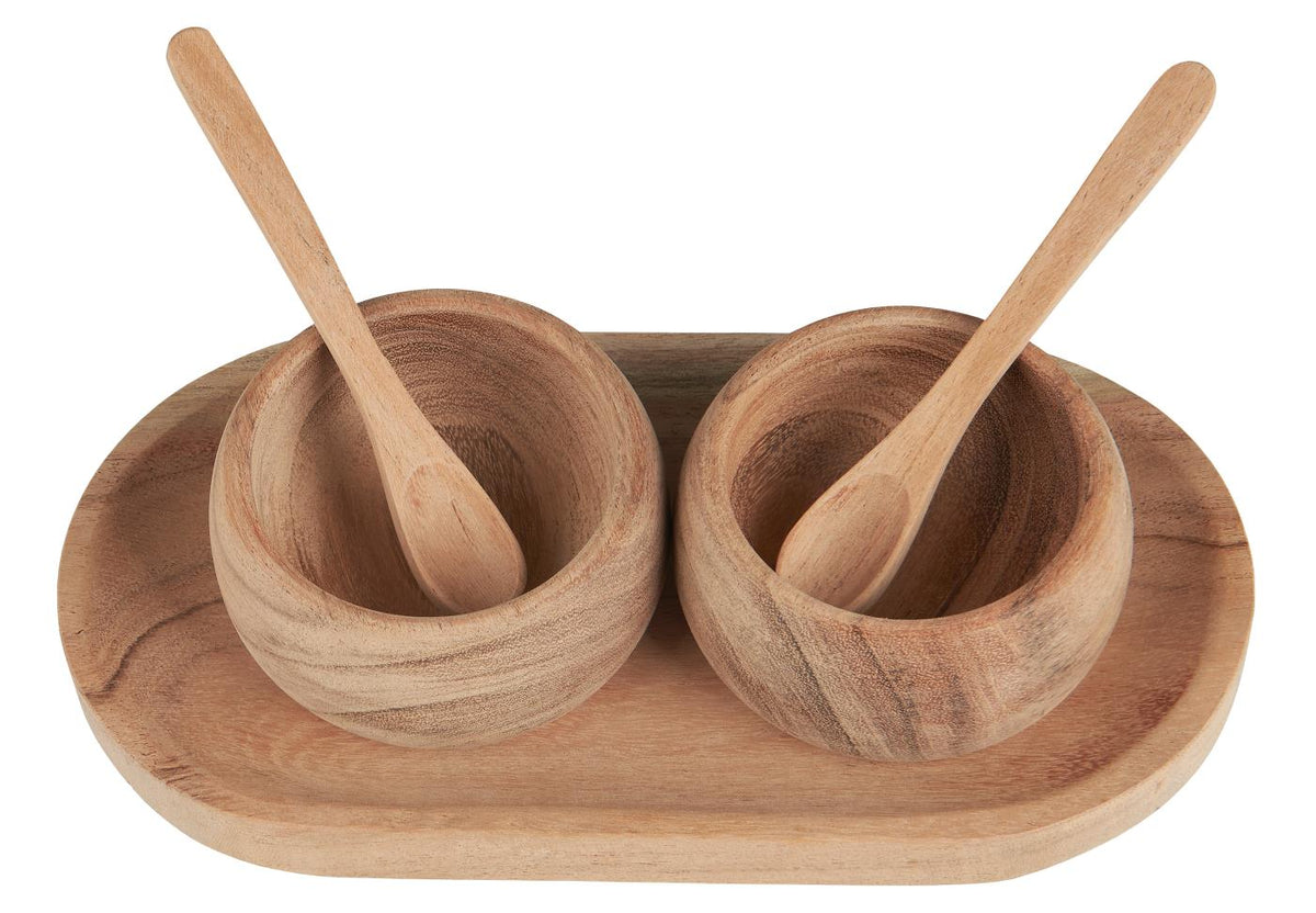 Salt og peber sæt set fra oven med to træskåle og tilhørende skeer på oval bakke i akacietræ.