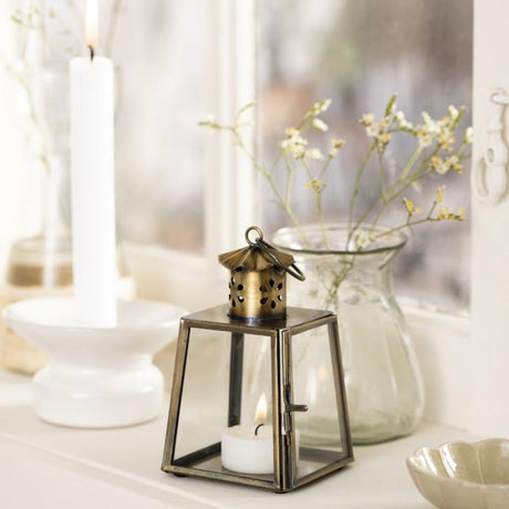 Ib Laursen guldfarvet mini lanterne 12 cm med blomstermønster i vindueskarm med levende lys