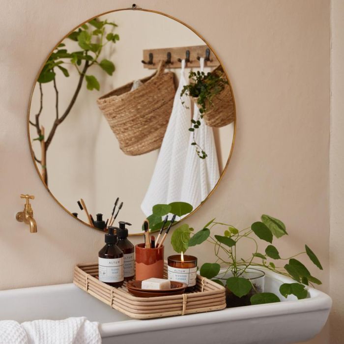 Ib Laursen ALTUM Golden Grass duftlys på bakke over badekar med sæber og pensler med rundt spejl på væg