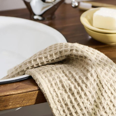 Ib Laursen Liseleje vaskeklud i beige ligger på kanten af en håndvask